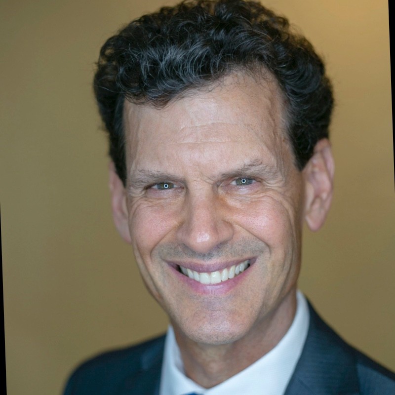 Tim Richardson, Founder and CEO of Total Development Resources. Professional profile head shot of shoulders and head. He wears a dark suit jacket, white button-down shirt and big smile.